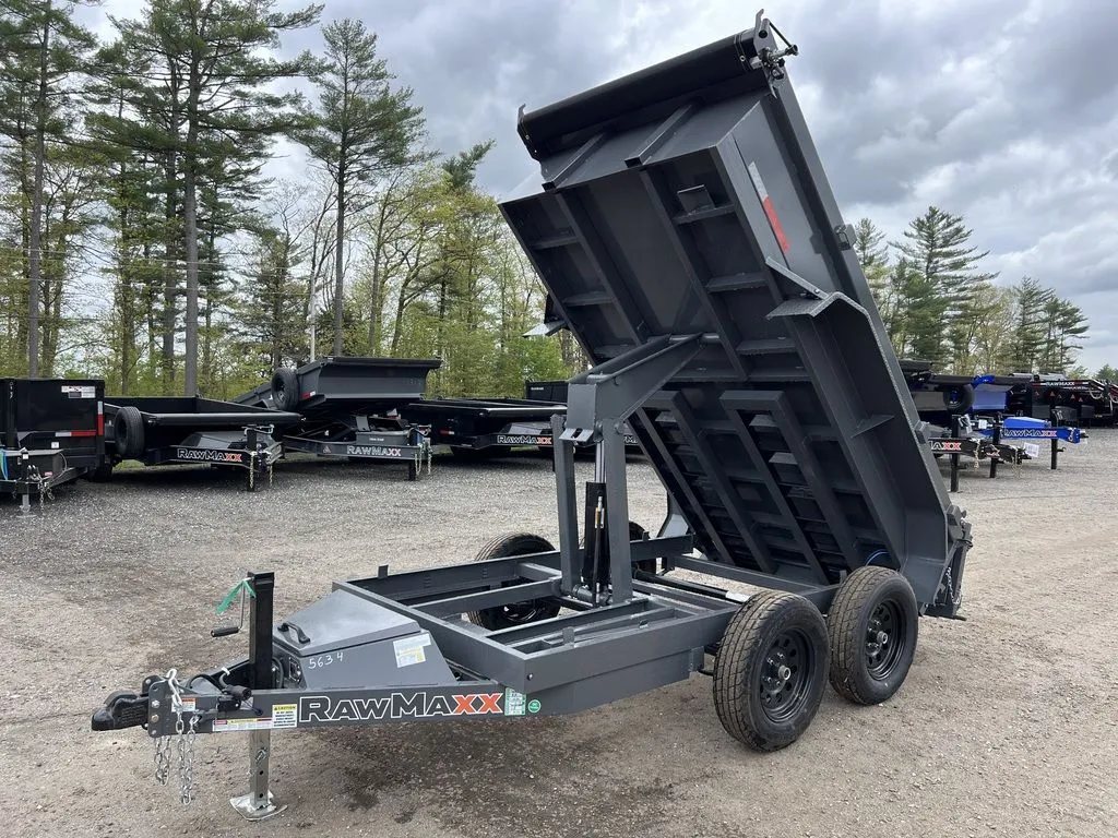 2024 RawMaxx 10 ft Dump Trailer – Shadow Grey – Three-quarter view from the front with the dump bed fully raised showing hydraulic piston