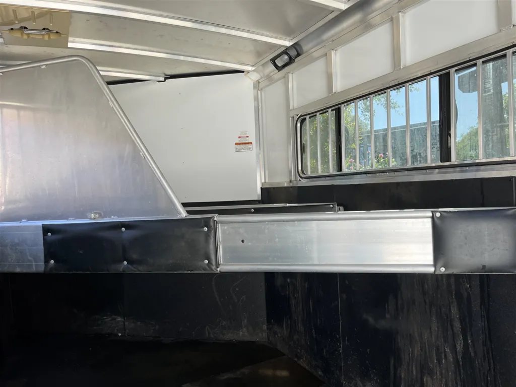 2013 Sundowner Sportsman 3 Horse Trailer – Extra-Large Tack Room – Interior horse area showing padded dividers and a window with bars
