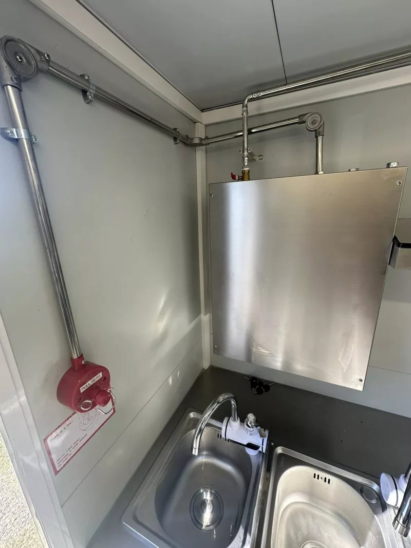 14 ft Food Trailer – Red Finish – Close up of a stainless steel sink and fire suppression system pull