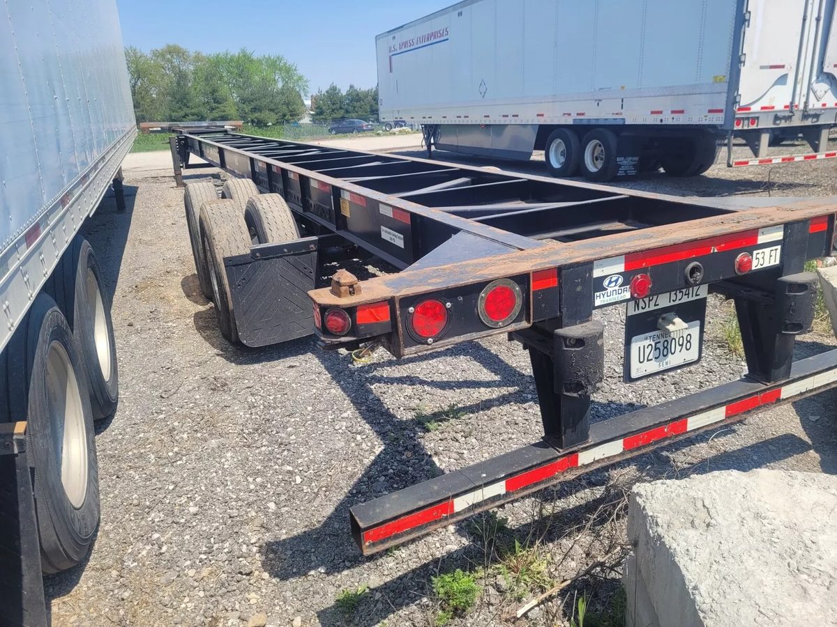 53ft Used Container Chassis – 2011, Spring Suspension – rear three-quarter view of empty container chassis in trailer yard