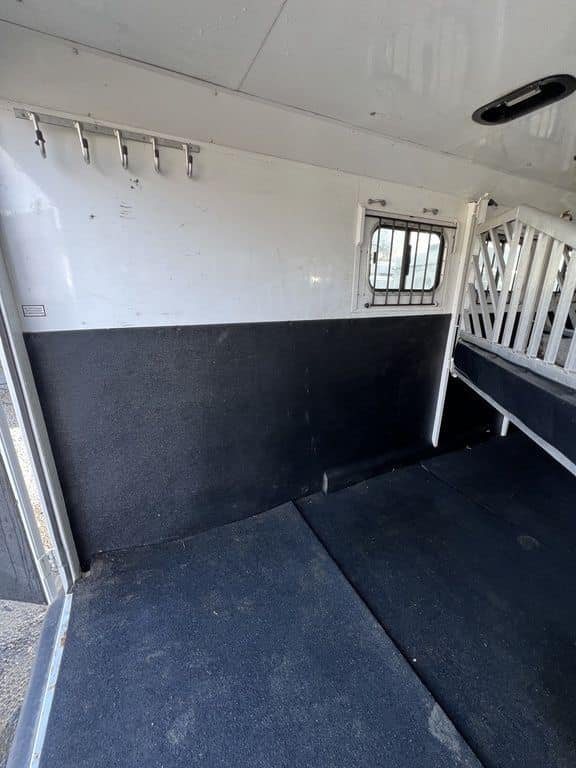 2020 Trails West Sierra 4 Horse Gooseneck – Comfort Package – Clean horse stall interior with black wall padding and drop down window