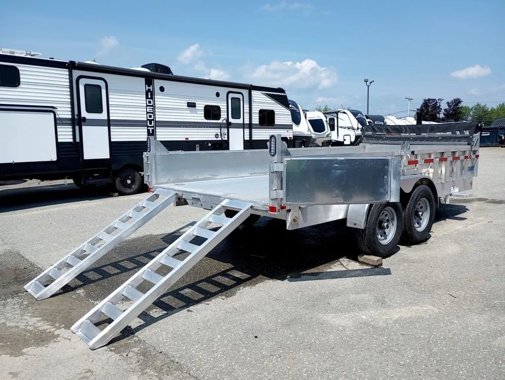 2025 Mission Trailers 16 ft Dump Trailer – Aluminum – Rear three-quarter view showing the open barn door and extended ramps