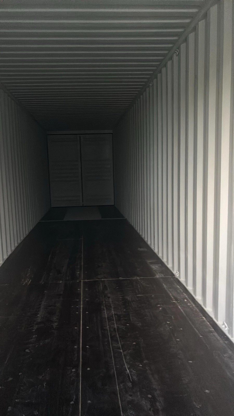 40ft High Cube Shipping Container – New / One-Trip – empty container interior with corrugated walls and dark wooden floor