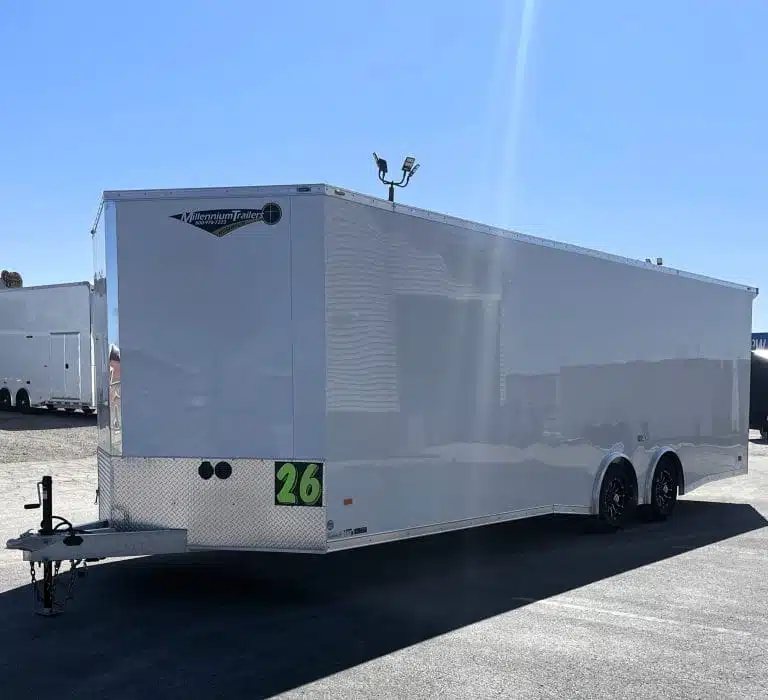 2026 Millennium 26 ft Car Hauler – White Aluminum – Left side view of the white enclosed trailer against a bright sky