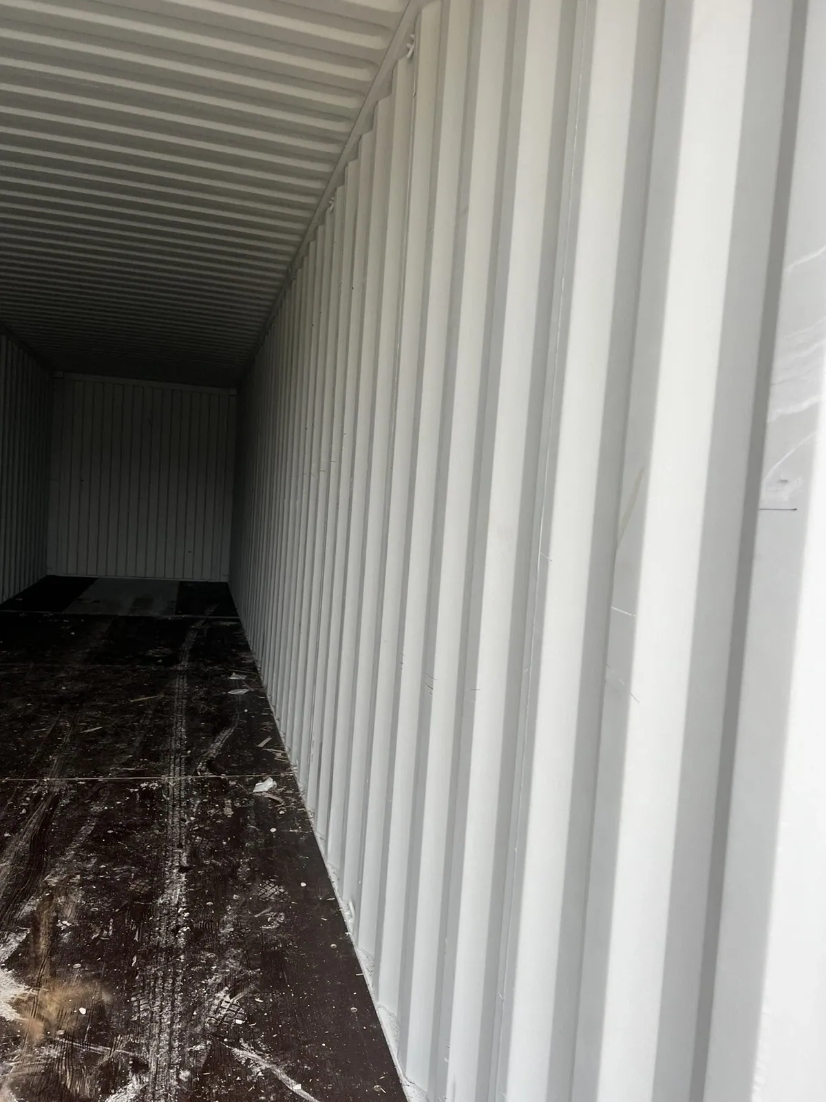 40ft High Cube Shipping Container – One-Trip, Double Doors – empty container interior with corrugated walls and dirty wooden floor