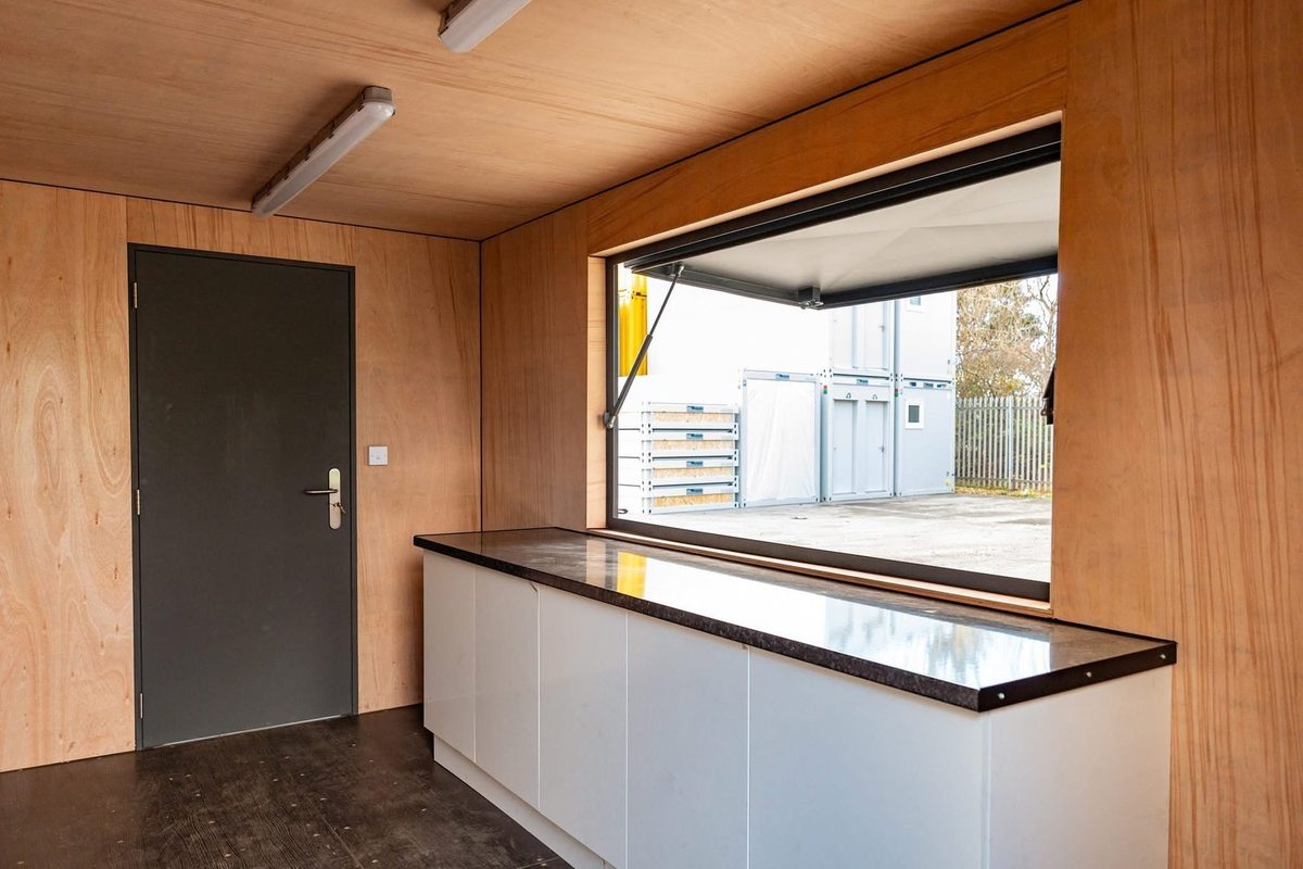 20ft Custom Container Kiosk – Serving Hatch and Insulated Interior – Wood-lined kiosk interior with counter and open serving hatch