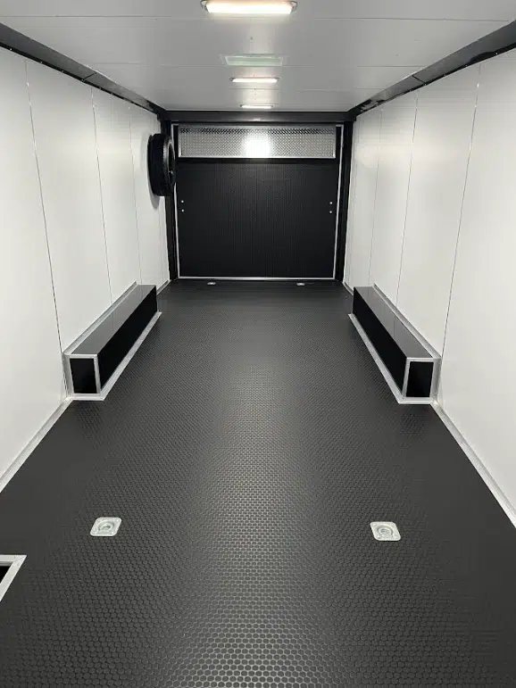 2025 Millennium 26 ft Car Hauler – Charcoal – Interior view looking toward the rear ramp door with black coin flooring and wheel wells