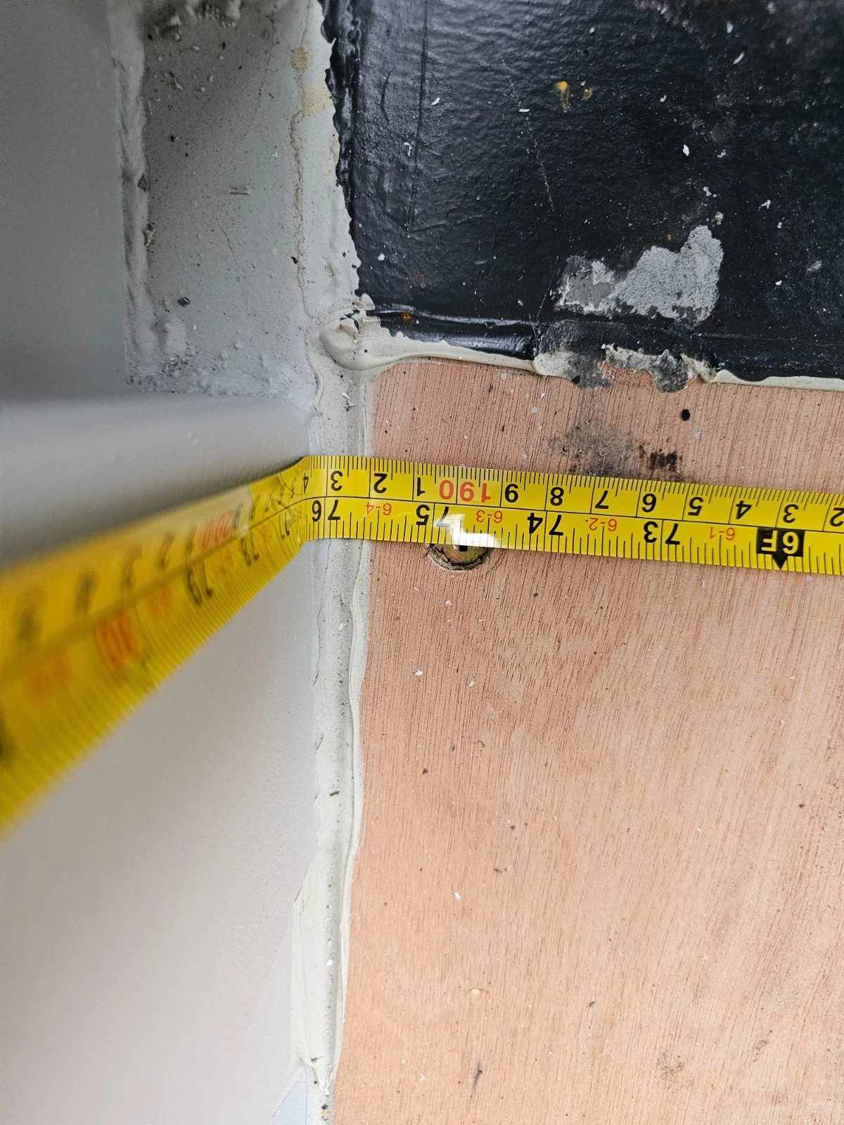 8ft New Shipping Container – Lockbox and Barred Windows – measuring tape across plywood floor beside metal wall