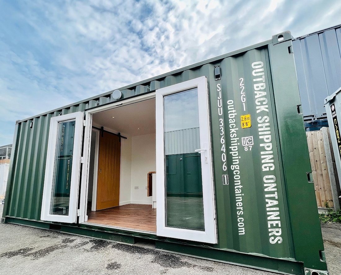 20ft Container Home – One Bed Box, 1 Bedroom – A 20ft refurbished shipping container converted into a modern living space featuring a sliding barn door and white-framed glass entry