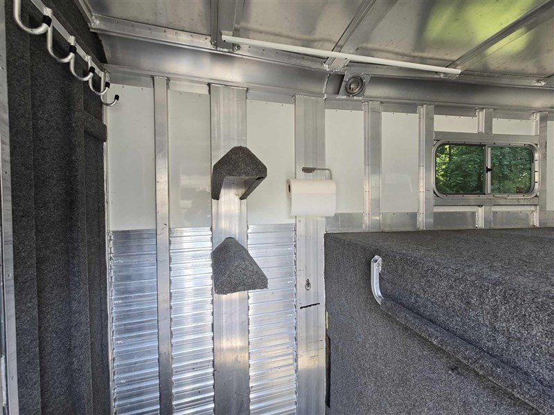 2000 C&C 2 Horse Gooseneck Trailer – Aluminum, Dressing Room – Interior of the dressing room showing bridle hooks, saddle racks, and carpeted walls