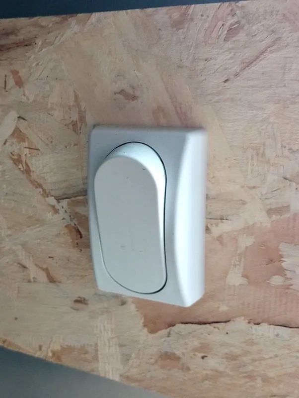2022 Sno Pro Trailers Hybrid 2.0 – Charcoal Snowmobile Trailer – A white rocker light switch mounted on a wood interior wall