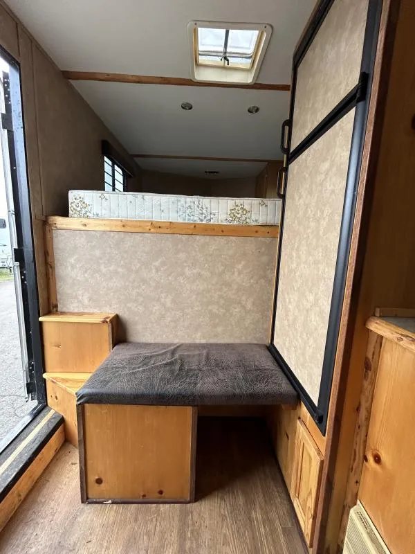 2002 Silverado 3 Horse Gooseneck Trailer – Wood Interior – Living area with a bench seat, wooden steps, and a built-in refrigerator