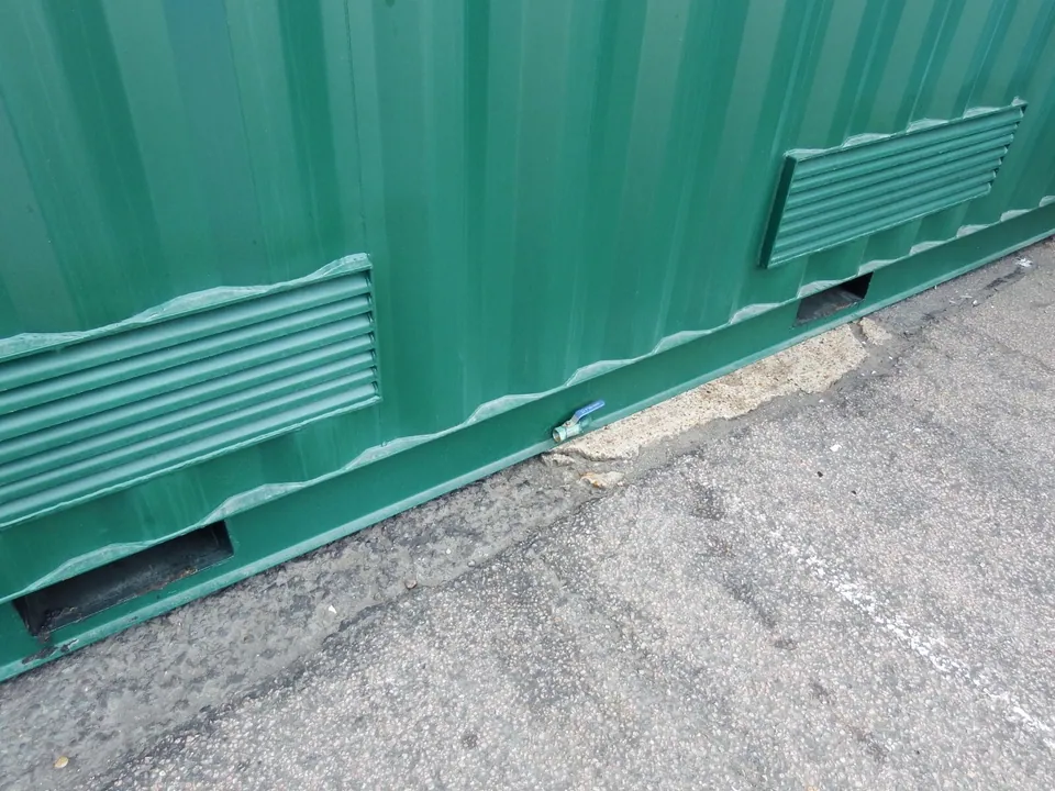 20ft Bunded Storage Container – Integrated Spill Containment – green container side with ventilation grilles and drain valve