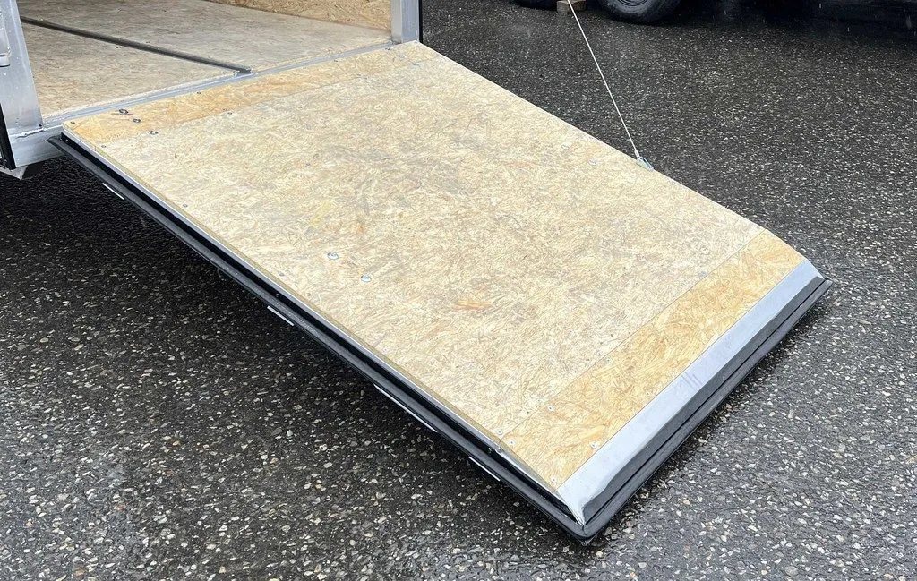 2024 Mission Trailers Crossover Trailer – Galvanized Package – Close-up of the lowered rear ramp door with wood surface