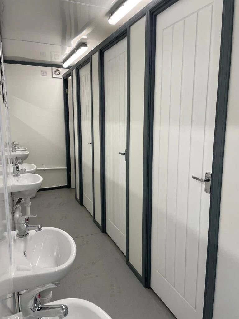 20ft Refurbished Container Toilet Block – Separate Compartments – narrow toilet block interior with sinks and closed cubicle doors