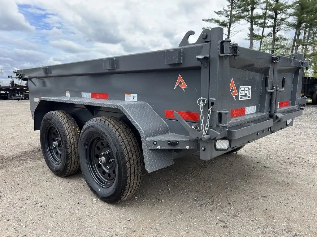 2024 RawMaxx 10 ft Dump Trailer – Shadow Grey – Rear three-quarter view showing the dual axles and rear barn doors of the trailer