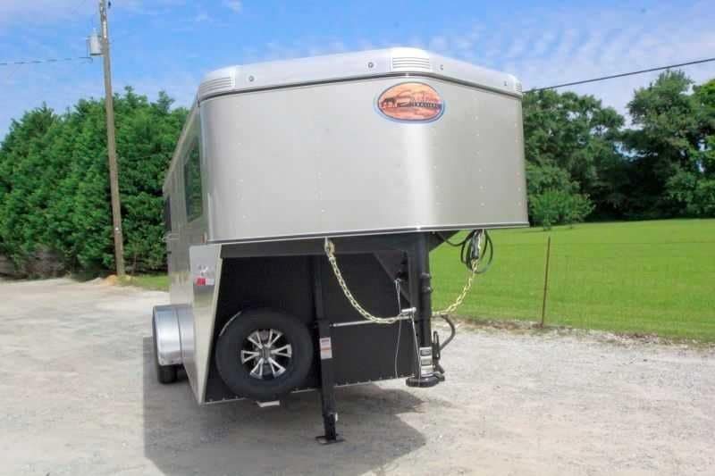 2016 Sundowner 3 Horse Gooseneck – Aluminum, Dressing Room – Front three-quarter view of the gooseneck hitch area including spare tire and chains