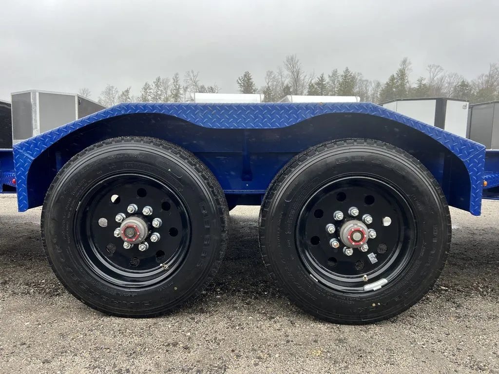 2022 Diamond C 24 ft Equipment Trailer – Max Ramps – Close up view of the dual axles and black wheels under blue fenders
