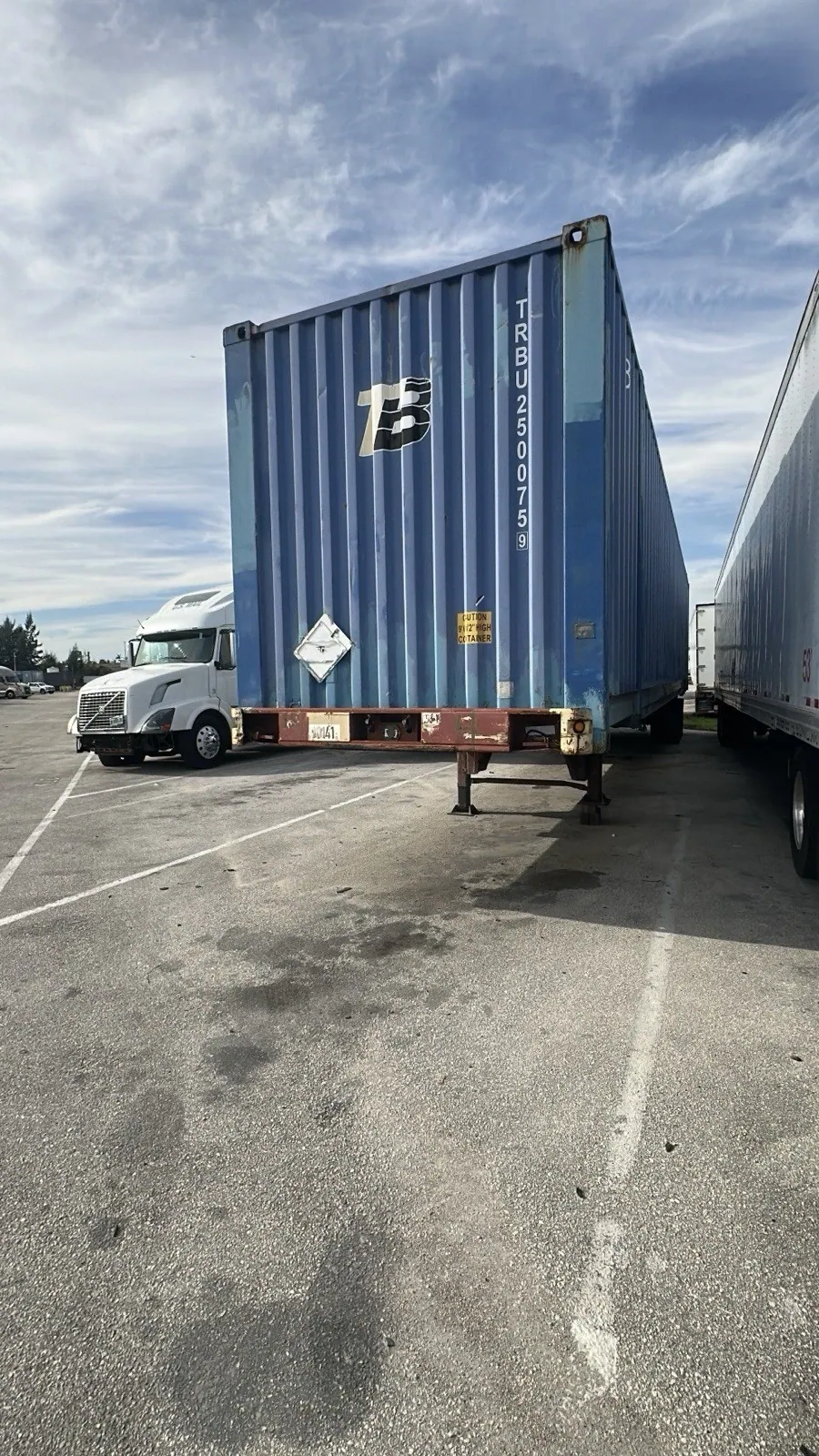 53ft High Cube Shipping Container – Used, Cargo Worthy – blue shipping container on chassis beside parked trucks
