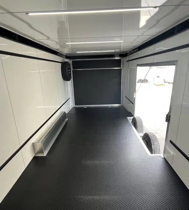 2026 ATC 24 ft Car Hauler – ROM 450, LifeTrac – Interior view facing the rear ramp door with black flooring and white walls