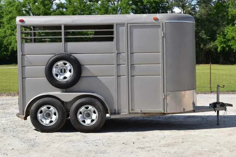 2010 Calico 2 Horse Trailer – Steel, Walk-In Dressing Room – Right side view of the trailer showing the dual axles and mounted spare tire