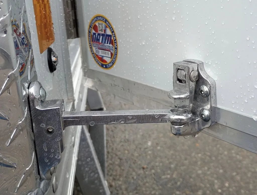 2024 Mission Trailers 12 ft Powersports – Side X Side – Close up of the metal door holder hardware keeping the side door open