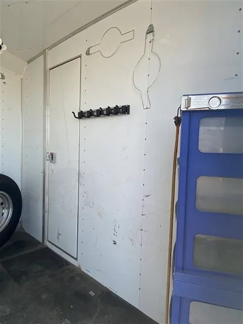 2000 Sooner 4 Horse Bumper Pull – Dressing Room, Awning – Interior tack room wall showing bridle hooks and a storage unit