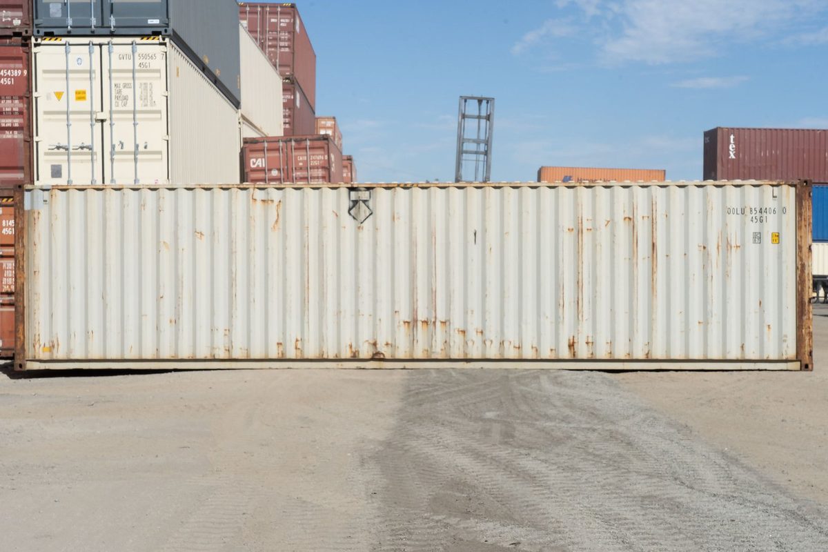 40ft Used High Cube Shipping Container – Storage Grade – side view of weathered container in stacked container yard