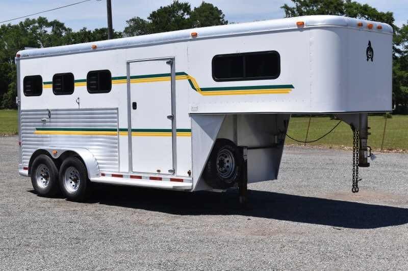 2006 Adam 7302 3 Horse Trailer – Aluminum, Dressing Room – A three-quarter exterior view of a white gooseneck horse trailer on gravel