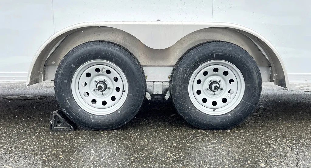 2024 E-Z Hauler 24 ft Trailer – Rear Canopy – Close-up of the tandem wheels and silver fenders on the trailer unit