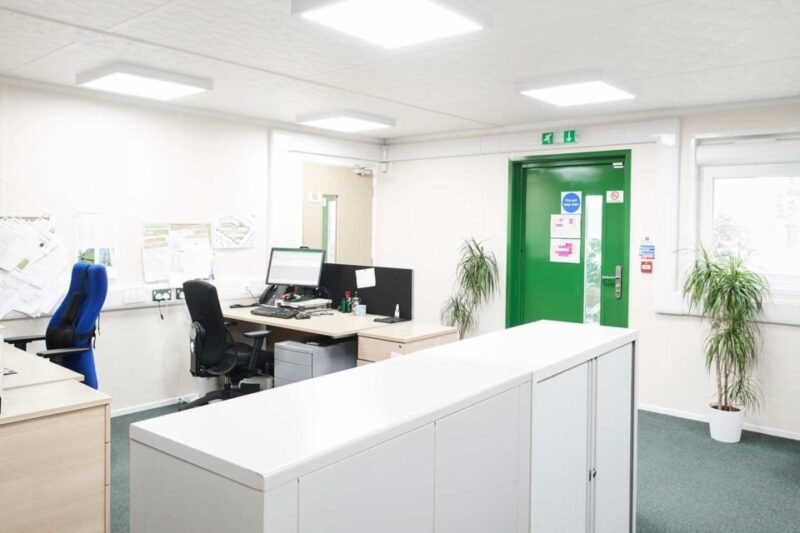 32 × 30 ft Modular Office – Green, 3 Bay – Bright interior office space with desks chairs computers and white storage units