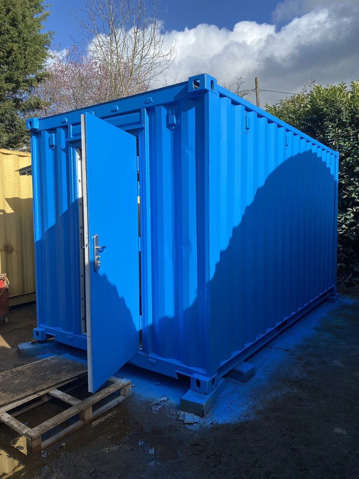 15ft Custom Container Bar & Kiosk – Side Service Hatches – three-quarter exterior of blue container with personnel door open