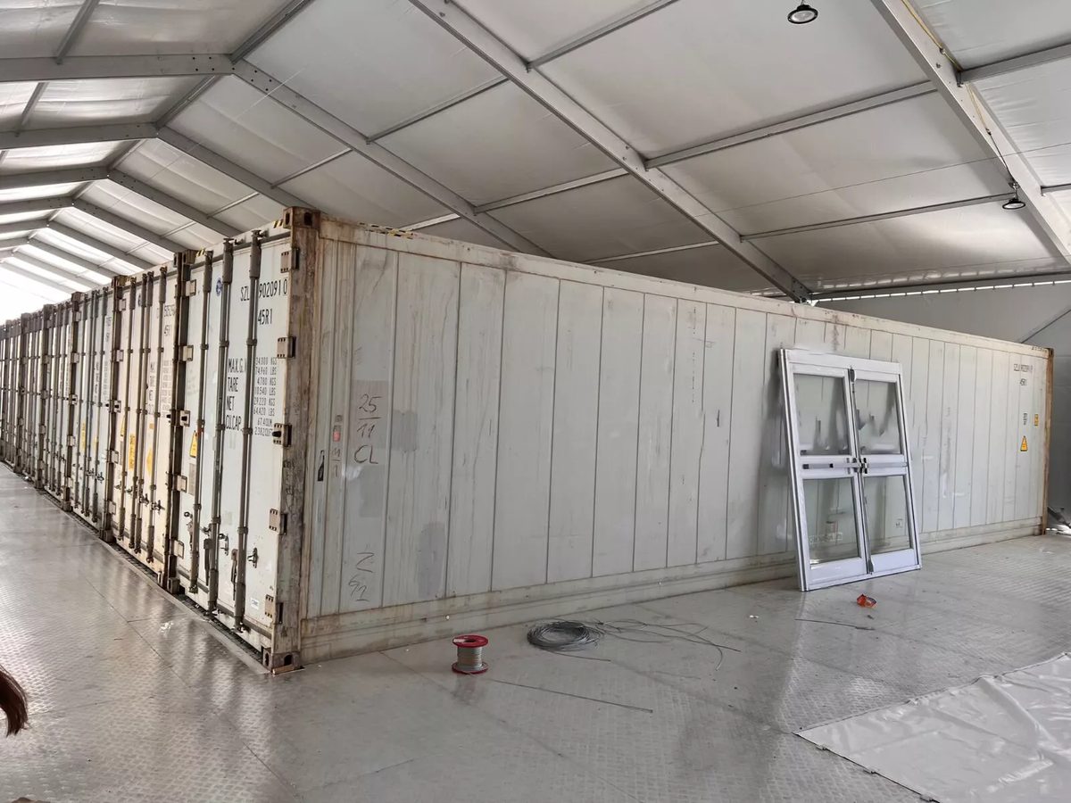 40ft High Cube Reefer Container – Carrier PrimeLINE – weathered refrigerated container indoors with loose doors leaning against side