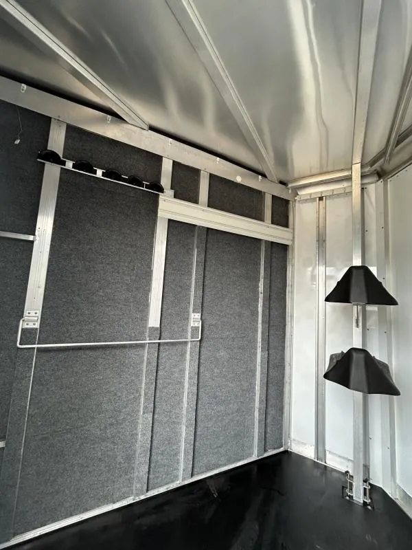 2007 Exiss SS-20 2 Horse Trailer – Collapsible Rear Tack – Interior of the tack room with grey carpeted walls and saddle racks
