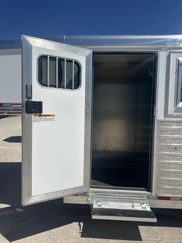 2020 Bloomer 4 Horse Stock Combo – Trainer Tack – Open side entry door leading into the dark interior of the trailer