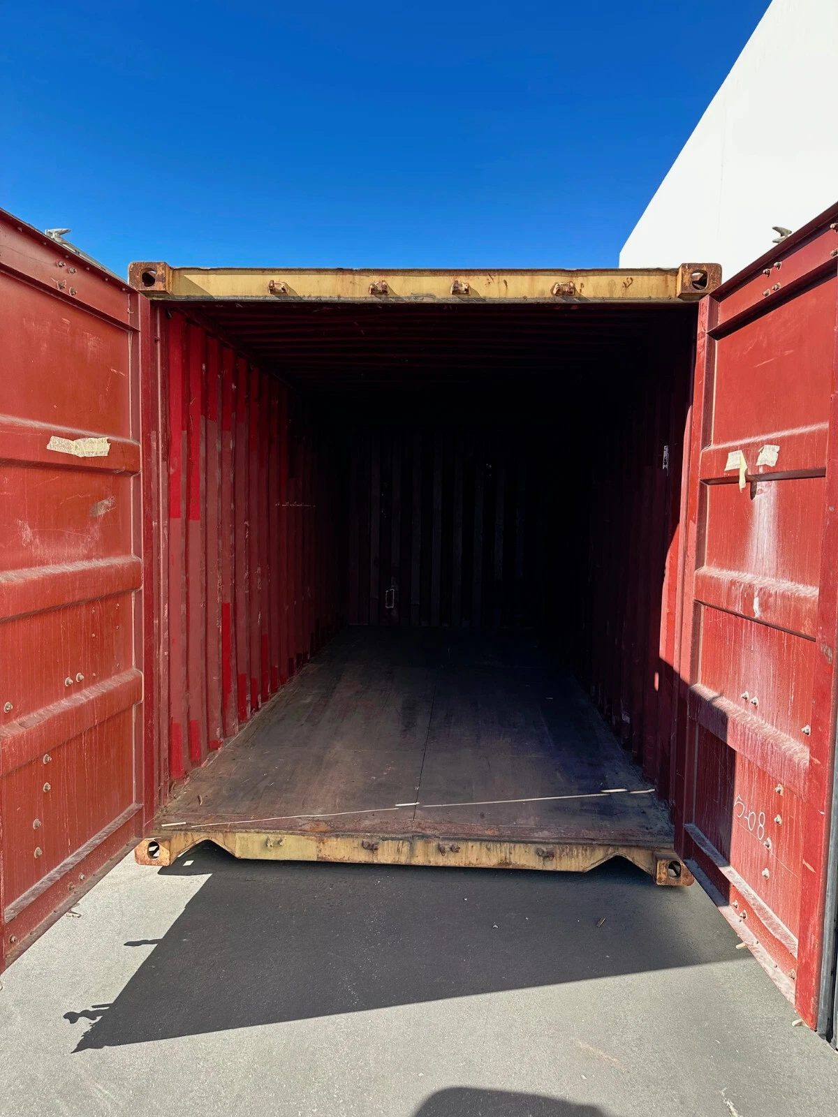 20ft Used Shipping Container – Yellow/Gold, Double Cargo Doors – open cargo doors revealing an empty shaded container interior