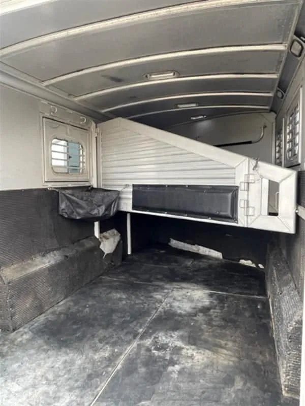 1999 Elite Custom 3 Horse Trailer – Rotating Saddle Rack – Interior horse area showing padded dividers and rubber-lined walls
