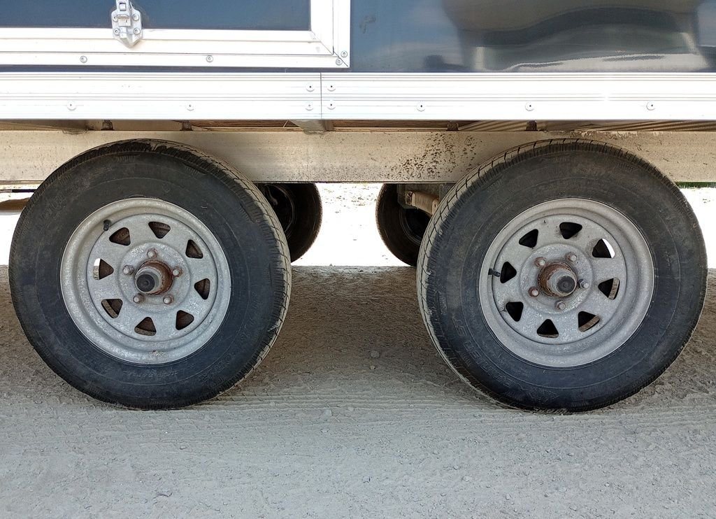 Mission Trailers 22 ft Snowmobile Trailer – 4-Place – Close-up of the tandem wheels and tires on the aluminum trailer frame