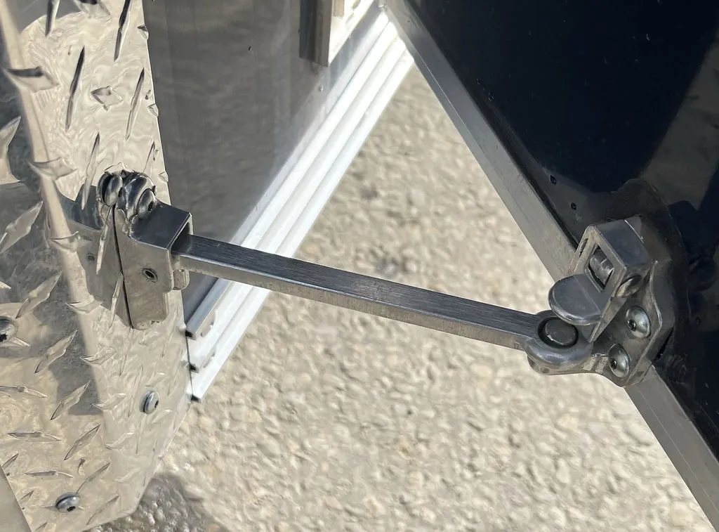 2023 High Country 14 ft Trailer – Blue, Drive-Through – A metal door hold-back arm securing the side entry door in an open position