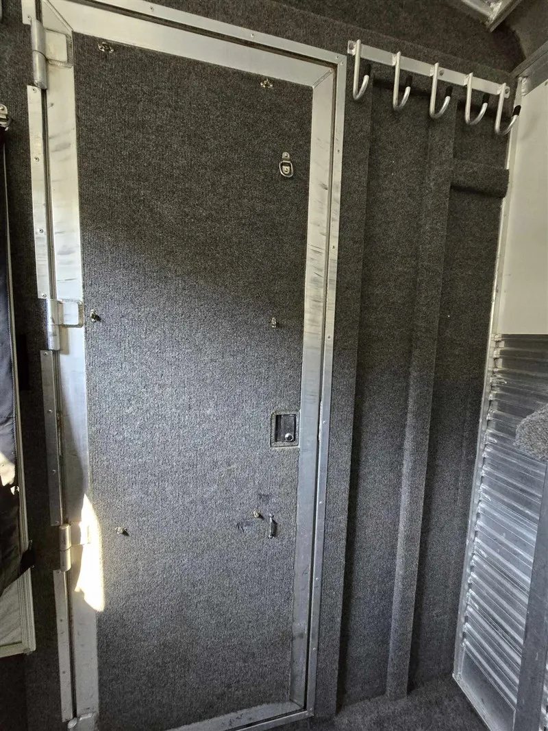 2000 C&C 2 Horse Gooseneck Trailer – Aluminum, Dressing Room – Inside the dressing room looking at the carpeted entry door and bridle hooks