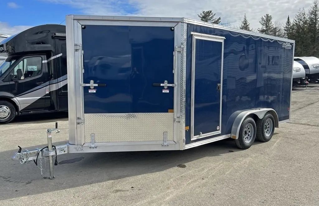 2023 High Country 14 ft Trailer – Blue, Drive-Through – Front three-quarter view of a blue enclosed trailer with a side door and front ramp