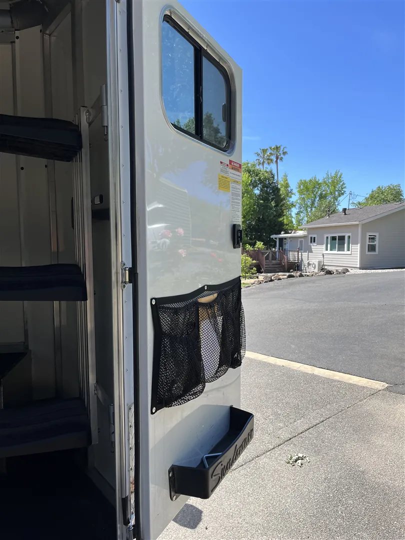 2013 Sundowner Sportsman 3 Horse Trailer – Extra-Large Tack Room – Close up of the open tack room door with storage mesh pockets and tray