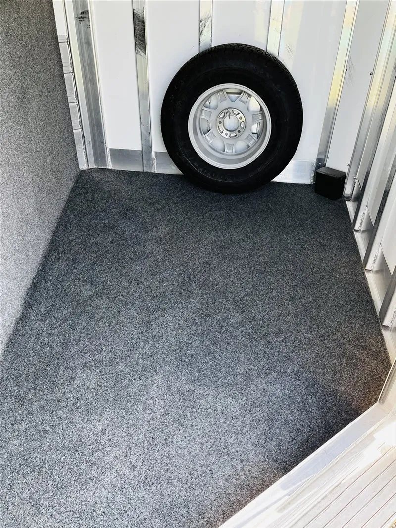 2015 4 Star 2 Horse Bumper Pull – Slant Load, Rear Tack – Floor view of the carpeted tack room with a spare tire against the wall