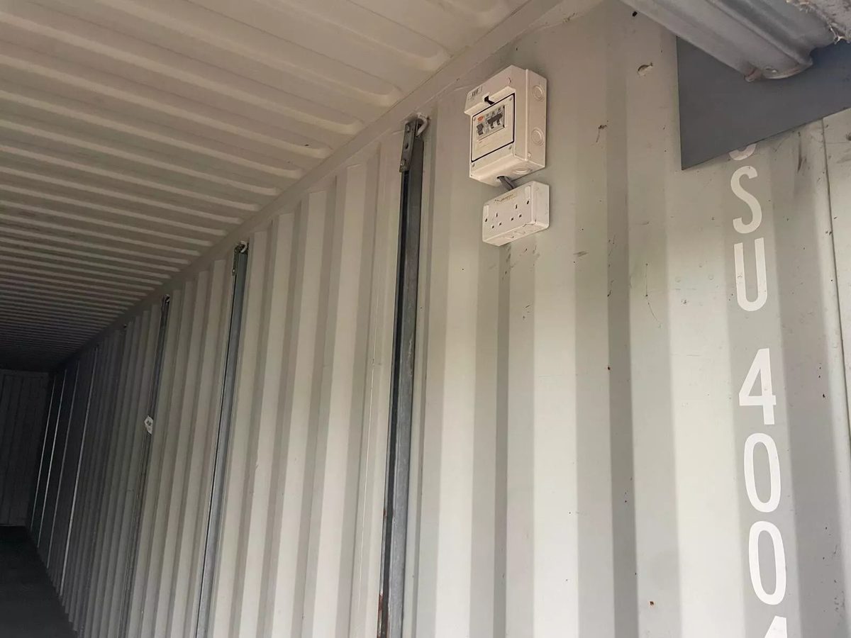 40ft Used Shipping Container – Roll-Up Door, Power & Lighting – electrical breaker box and double socket on container interior wall