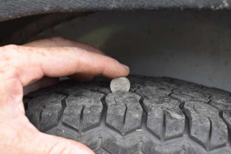 2018 Adam 3 Horse Gooseneck Trailer – Dressing Room – A hand holding a coin in the tire tread to show depth