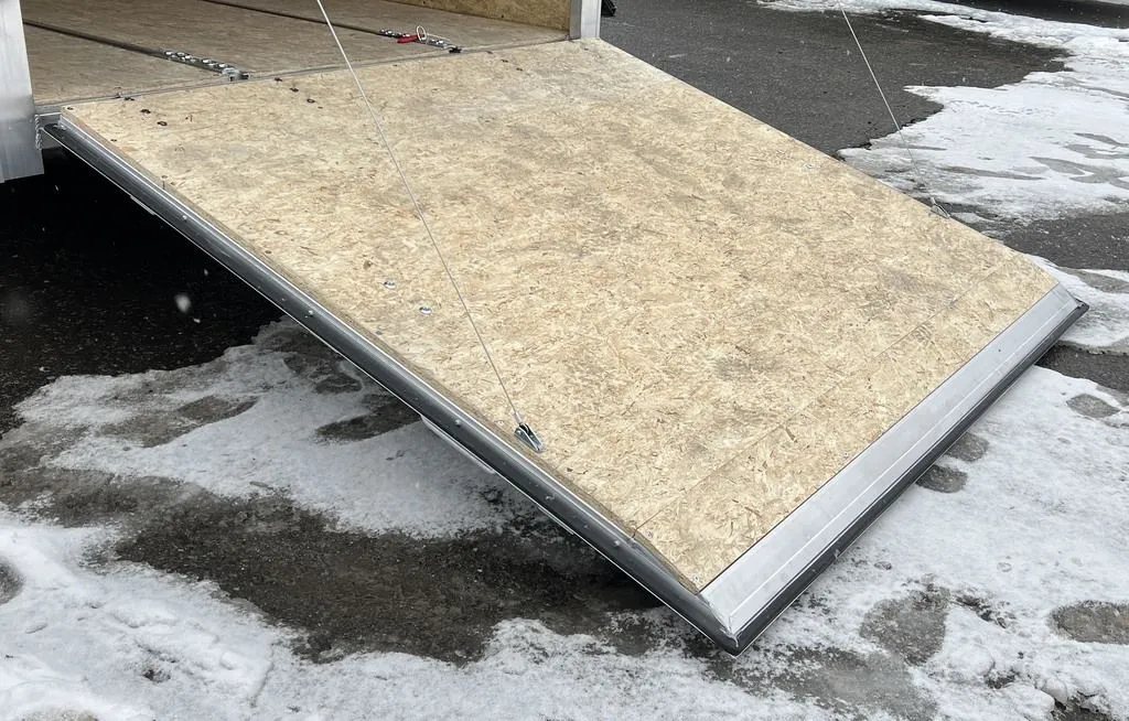 2024 E-Z Hauler 24 ft Trailer – Rear Canopy – Wooden rear ramp door extended down to the ground in snowy conditions