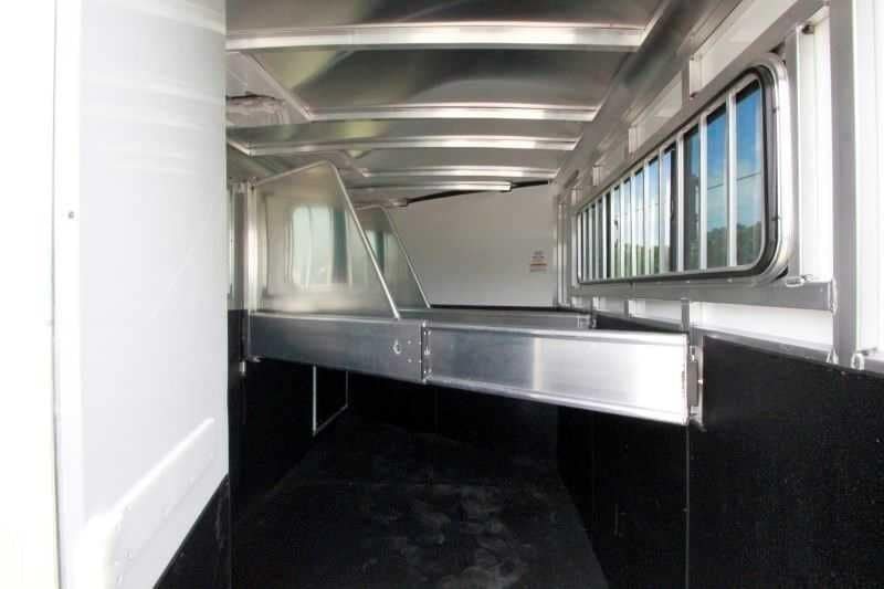 2016 Sundowner 3 Horse Gooseneck – Aluminum, Dressing Room – View down the length of the horse stalls showing dividers and ventilation windows