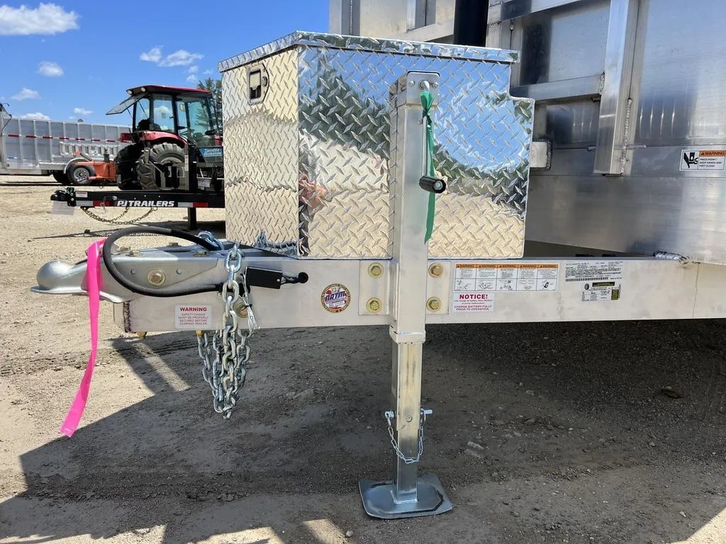 2024 Cargo Pro 12 ft Dump Trailer – Aluminum – Close-up of the trailer hitch, safety chains, and manual tongue jack