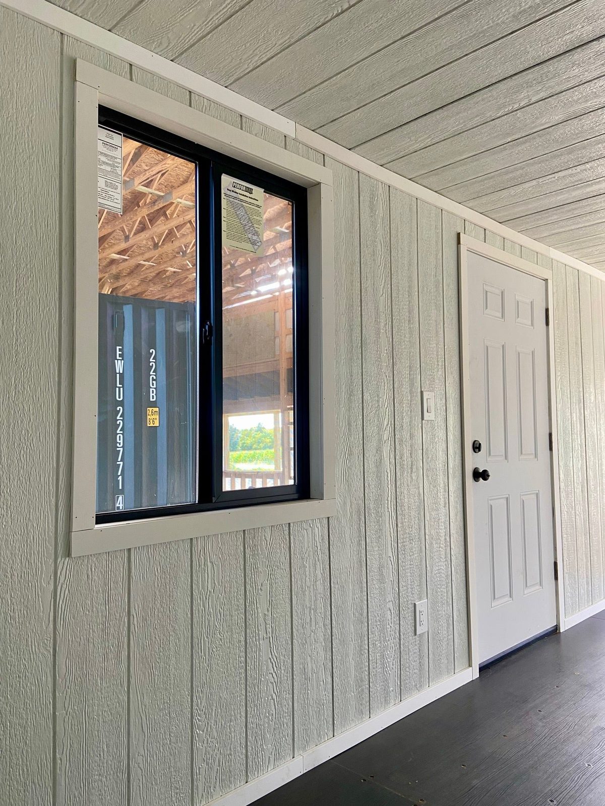 20ft Modular Container Office – LED Lighting, Two Windows – empty office interior with paneled walls, window and entry door
