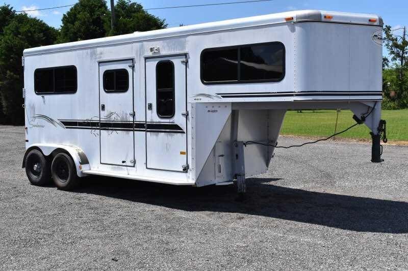 2000 Sundowner 2 Horse Gooseneck Trailer – Dressing Room – A three-quarter exterior view of a white gooseneck horse trailer on gravel